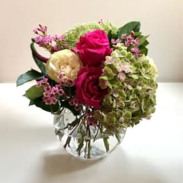 Pink and cream roses with hydrangea in a clear glass vase