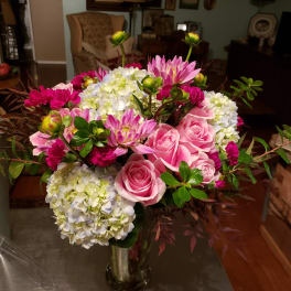 Pink roses and hydrangeas in a glass vase with magenta blooms