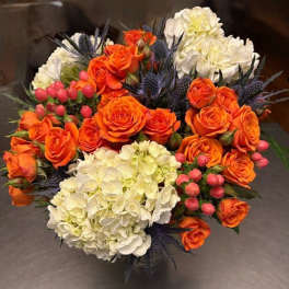 Bouquet of orange roses and white hydrangeas with pink berries