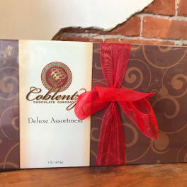 Box of assorted chocolates tied with a red ribbon
