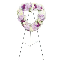 Heart-shaped floral wreath on a standing easel with white and lavender flowers