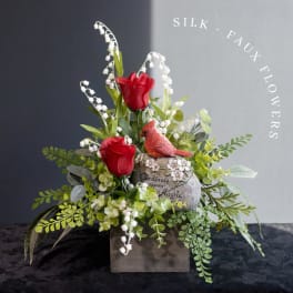 Silk red roses and white lily-of-the-valley in a rustic box with a cardinal figurine