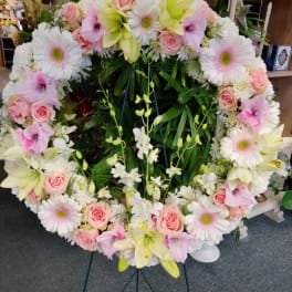 Large heart-shaped floral wreath with pink and white flowers on an easel