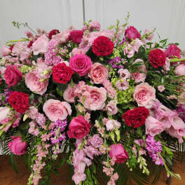 Large pink and red floral arrangement with roses and mixed blooms