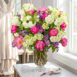 Pink peonies and white hydrangeas in a clear glass vase