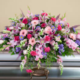 Large pink and purple funeral spray on a casket