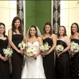 Bride and bridesmaids holding white bouquets in black dresses