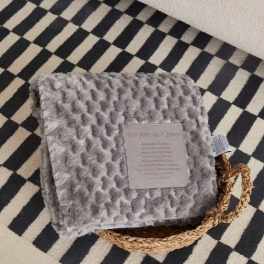 Gray plush blanket with a sympathy message card and braided handle
