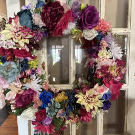 Colorful floral wreath made of assorted blooms on a window frame