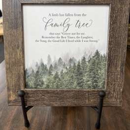 Framed memorial sign with a forest scene and text about a family tree