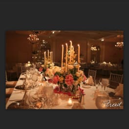 Tall floral centerpieces with candles on a decorated banquet table