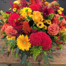 Bright mixed bouquet with yellow daisies, orange roses, and red blooms