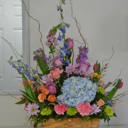 Colorful mixed flower arrangement in a woven basket