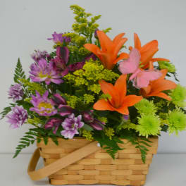Basket arrangement with orange lilies and purple flowers