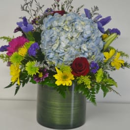 Colorful bouquet with blue hydrangea in a green vase