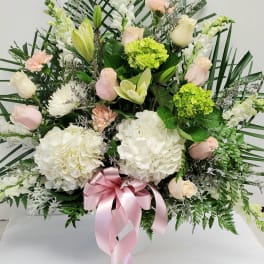 Large floral arrangement with white and pale pink blooms in a white vase