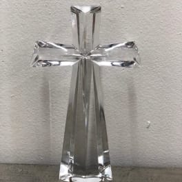 Clear glass cross figurine on a plain surface