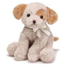 Small plush puppy dog with cream fur, brown ears, and a bow around its neck