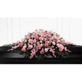 Pink floral casket spray on a black casket