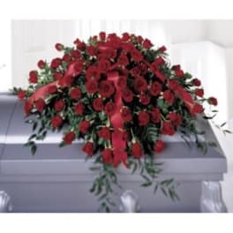 Large red rose casket spray with trailing greenery