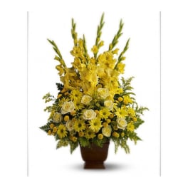 Tall yellow floral arrangement in a brown urn