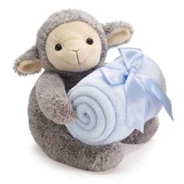 Plush lamb holding a rolled light blue blanket with a ribbon