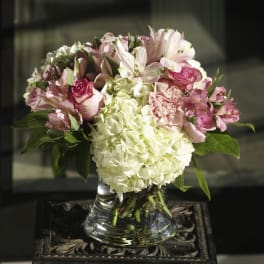 Pink and white floral arrangement in a clear glass vase