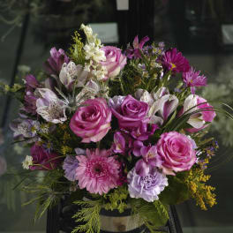 Pink and purple mixed bouquet in a container