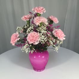 Pink carnations arranged in a bright pink vase