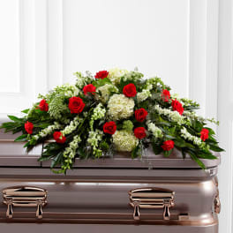 Red roses and white flowers arranged on a casket