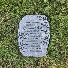 Memorial stone with engraved text lying in grass