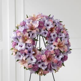 Lavender and pink floral wreath on a black stand