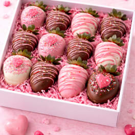 Box of chocolate-covered strawberries with pink and white drizzle