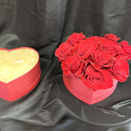 Red roses in a heart-shaped box beside an empty matching box