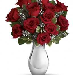 Red roses arranged in a clear glass vase