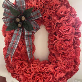 Red carnation wreath with a plaid bow and berry accent
