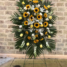 Standing floral spray with sunflowers, yellow roses, and white lilies