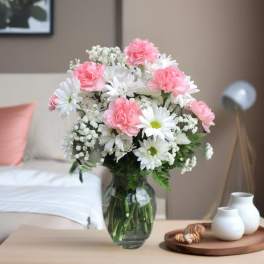 Pink carnations and white daisies in a glass vase
