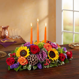 Sunflower and rose centerpiece with three orange candles