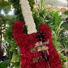 Red floral guitar-shaped tribute with a white neck and ribbon bow