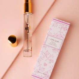Perfume spray bottle with a pink patterned box on a blush background