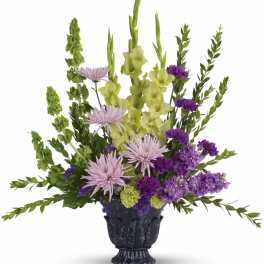 Purple and green floral arrangement in a dark vase