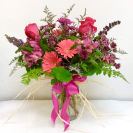 Pink and purple mixed bouquet in a glass vase with a ribbon