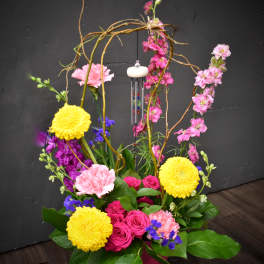 Colorful floral arrangement with roses, carnations, and yellow mums in a vase