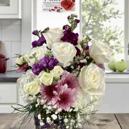 White and purple rose bouquet in a glass vase