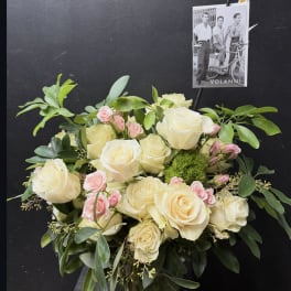 Cream and pink rose bouquet in a glass vase with greenery