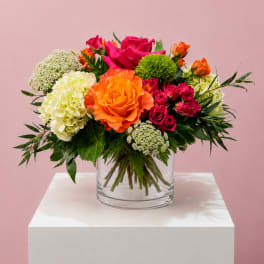Bright mixed bouquet of roses and hydrangeas in a clear glass vase