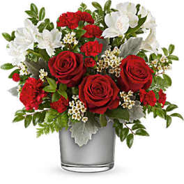 Red roses and white flowers arranged in a glass vase
