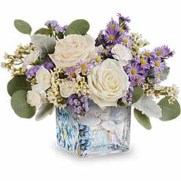 White roses and purple daisies in a square glass vase