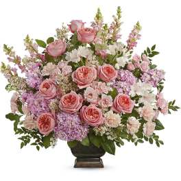 Pink roses and mixed blooms arranged in a dark vase